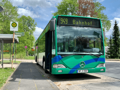 Bus der zum Bahnhof fährt hält an einer Bushaltestelle