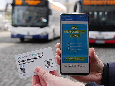 Deutschlandticket als Chipkarte in der Hand und per App auf dem Handy offen