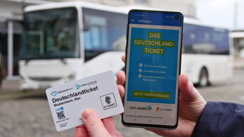 Deutschlandticket per Karte und auf Handy in den Händen 